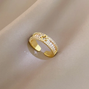 Makroaufnahme von Kleeblattring in Gold mit Sterndesign und funkelnden Kristallen