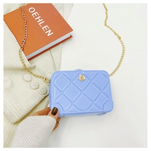 Detailed macro view of a blue quilted PVC jelly bag featuring a gold chain and flower clasp