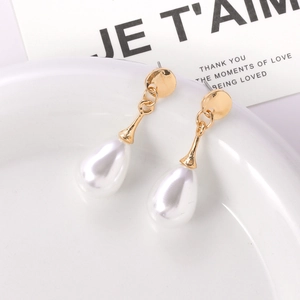 Elegant gold drop earrings with white baroque style waterdrop pearls on ceramic tray