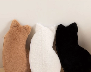 Three plush cat-shaped pencil cases in brown, white, and black with soft fur texture