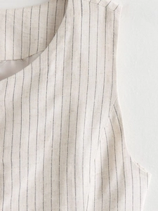 Close-up of beige pinstripe vest showing woven linen texture and neckline detail