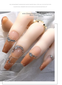 Detailed view of mini zircons and micro beads on nails over white lace background