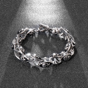 Close-up of double layer skull links on polished steel bracelet with toggle clasp