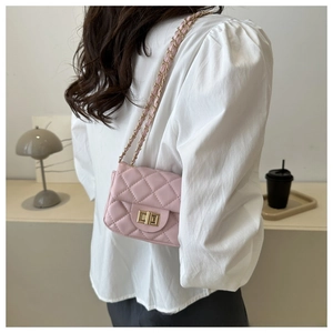 Close-up of pink quilted leather bag with gold metal twist lock and chain strap