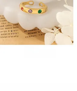 Détail d'une bague dorée vintage avec pierres colorées incrustées sur fond décoratif