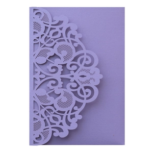 Detail of purple laser-cut invitation sleeve with intricate floral lace pattern on cardstock