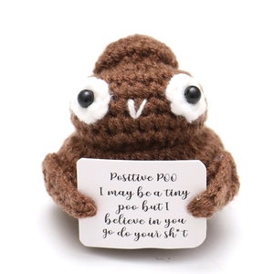 Close-up of handmade crochet positive poo doll with encouraging message card
