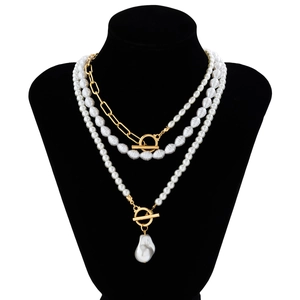 Close-up of baroque pearl necklace with gold OT buckle on black mannequin stand