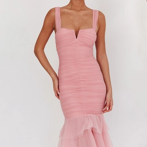 Detail of pink bodycon dress featuring pleated V-neck bodice and ruffled mesh mermaid hem