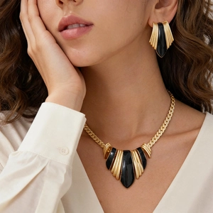 Vintage gold metal necklace and earrings set with black enamel and sunburst texture