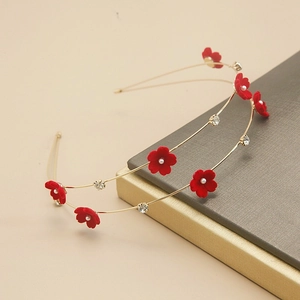 Detail of gold double-layer floral headband with red velvet flowers and pearl accents