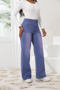 Dettaglio dei jeans blu a vita alta con gamba larga e trama del tessuto di qualità sul modello
