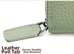 Dettaglio del tirazip in pelle verde menta con texture a grana e anello in metallo