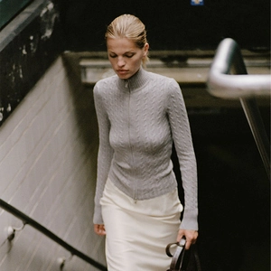 Détail du pull en maille torsadée grise avec fermeture éclair et coupe ajustée