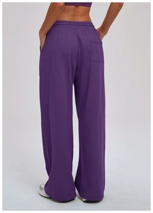 Detail view of purple high-waisted loose sweatpants with a minimalist back square pocket