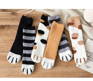 Close-up of fluffy coral fleece socks with cute cat paw patterns in various colors