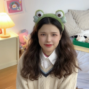 Close-up of green plush frog headband with big cute eyes for skincare routine