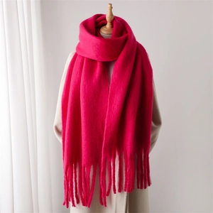 Détail d'une écharpe en mohair magenta doux avec franges portée sur un manteau beige