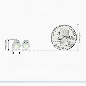 Luminous owl stud earrings in S925 silver with dimensions of 10mm by 8mm next to a coin