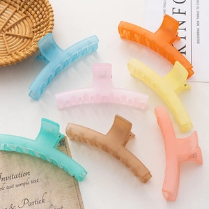 Flat lay of colorful matte plastic hair claws in blue orange and pink tones