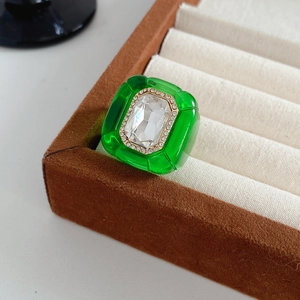 Vue macro d'une bague vintage en résine verte avec cristal dans un écrin en velours