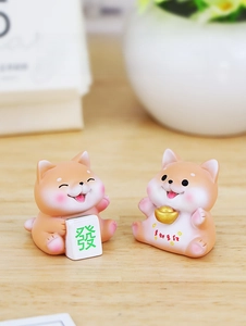 Close-up of cute resin shiba inu figurines holding gold ingot and mahjong tile for luck