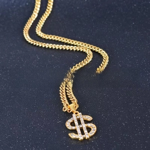 Macro shot of hip-hop gold Cuban link necklace with iced-out dollar sign pendant detail