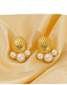 Detail view of gold titanium steel earrings with strawberry texture and white pearls