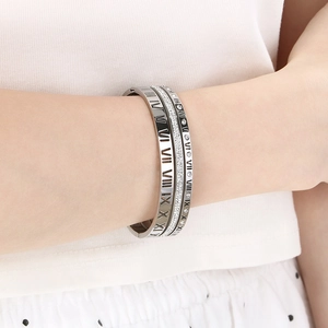 Detailed shot of silver titanium steel bangles with Roman numerals and sparkling crystals
