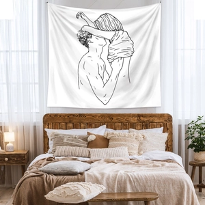 Detail of artistic line drawing tapestry on a white fabric hanging above a wooden bed