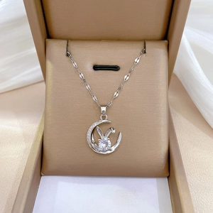 Detailed view of silver rabbit and moon necklace with sparkling zircons in a jewelry box