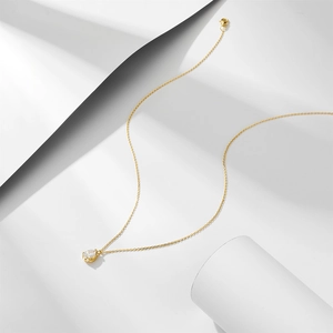 Macro shot of gold S925 sterling silver chain with teardrop zircon pendant and lobster clasp
