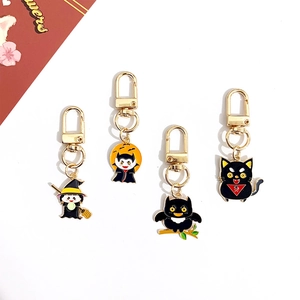 Detail of four cartoon Halloween keychains featuring a witch vampire owl and black cat