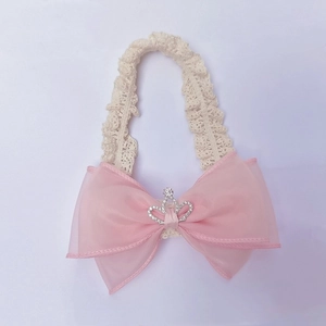 Detail of pink bow baby headband with silver crown and beige lace elastic band