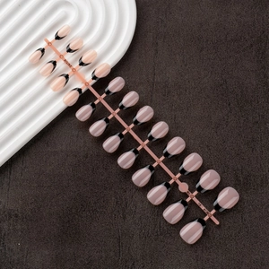 Detailed view of 24pcs nude French false nails with black tips on a professional flat lay