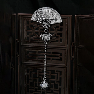 Detailed close-up of antique silver plum blossom fan brooch with butterfly tassel pendant
