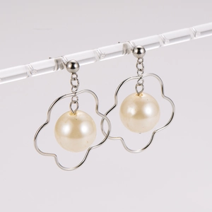Minimalist silver irregular hollow flower earrings with hanging pearl on display stand