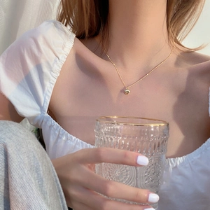 Elegant gold heart pendant necklace for women shown on a model in a minimalist style