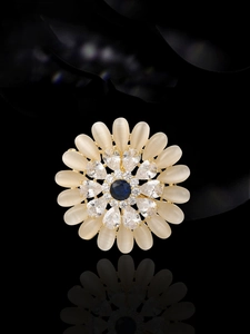 Detail of sunflower brooch featuring cat eye stones, blue gem and zircon inlay