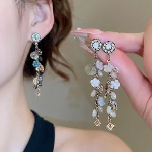 Orecchini pendenti a fiore con cristalli blu e aghi d'argento su modella