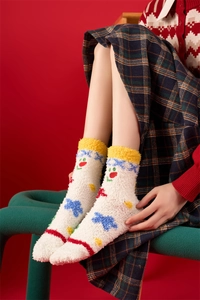 Close-up of thick white coral fleece Christmas socks with colorful cartoon embroidery