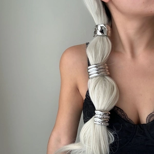 Minimalist silver metal hair cuff set with textured surface on model's ponytail