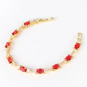 Gold plated bracelet featuring oval red gemstones and clear triangular zircon accents