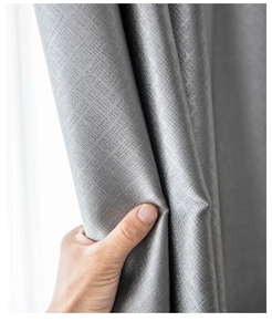 Close-up of textured grey blackout curtain fabric showing weave detail and draping