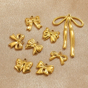 Detailed view of assorted gold stainless steel bow pendants for DIY jewelry crafting