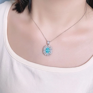 Elegant S925 sterling silver necklace featuring oval blue gemstone and diamond halo on model