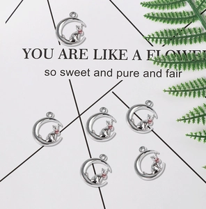 Détail de pendentifs lune et chat en argent avec pierres roses pour la création de bijoux