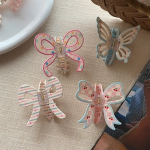Detailed set of four hair claws featuring pink polka dots, blue butterflies and cherry motifs