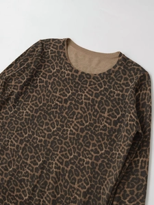 Close-up detail of leopard print knit sweater with ribbed round neckline and soft texture