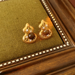 Detailed close-up of gourd-shaped vintage earrings with tiger eye stone and gold texture
